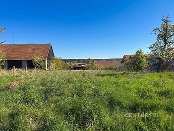 Prostorná zahrada s výhledem na okolní krajinu, zástavba s dřevěnou střechou, klidná lokalita, možnosti výstavby nebo rekreace.