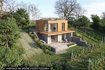 Moderní dům s dřevěným obkladem, zasazený v zalesněné krajině, s velkými okny a terasou, představuje inspirativní využití pozemku.