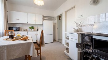 Kuchyň s retro kamny, světlý interiér, plovoucí podlaha, jídelní kout, vestavěné police, moderní spotřebiče