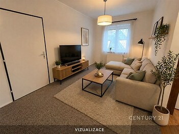 Světlý obývací pokoj s moderním designem, béžový koberec, pohodlná rohová sedačka a velká okna, která zajišťují dostatek přirozeného světla.