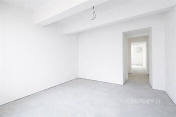 Prázdný pokoj s bílými stěnami, betonovou podlahou a minimalistickým designem, vhodný pro vlastní úpravy a moderní interiér