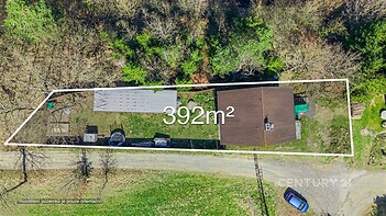 Letecký pohled na pozemek o rozloze 392 m² s rodinným domem a zahradou, obklopený přírodou, vhodný pro rekreační nebo trvalé bydlení.