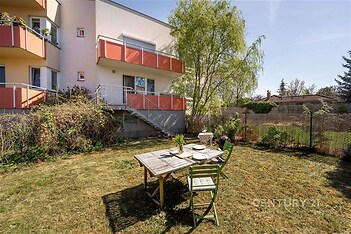 Udržovaná zahrada s venkovní terasou, stůl s židlemi, vhodné pro relaxaci. Klidná lokalita, ideální pro rodinné bydlení.