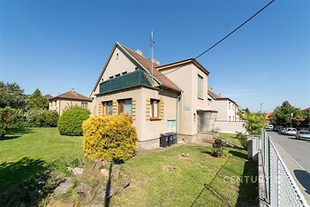 Rodinný dům s velkou zahradou, cihlová fasáda, šikmá střecha, klidná lokalita, vhodný pro rodiny hledající soukromí a prostor.