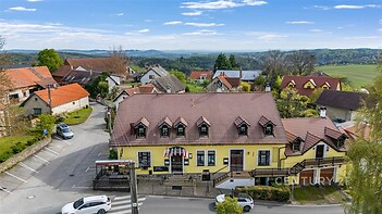 Střešní byt v historickém domě se šikmou střechou, dřevěnými prvky a malebným výhledem na okolní krajinu, klidná lokalita na venkově.