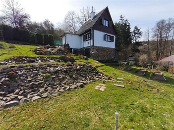 Rustikální chata s kamenitou terasou a udržovanou zahradou, v klidné přírodní lokalitě. Dům ve výborném stavu s dřevěnými a kamennými prvky.