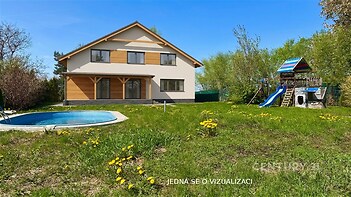 Dům s moderní fasádou, zahrada s bazénem a dětským hřištěm, klidná lokalita.