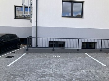 Prázdné parkovací místo s dlažbou, označené číslem 39, vedle moderní budovy. Vhodné pro parkování rezidentů v městské oblasti.