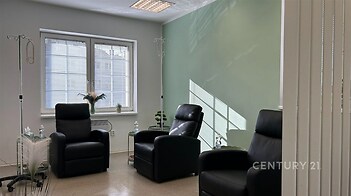 Prázdná místnost s okny, koženými sedačkami, moderní interiér, světlá dlažba, čisté světlé stěny, minimalistické vybavení