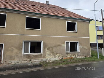 Průčelí staršího domu s omítkou v horším stavu, velká okna, rekonstrukce nutná, vhodné pro investiční příležitost