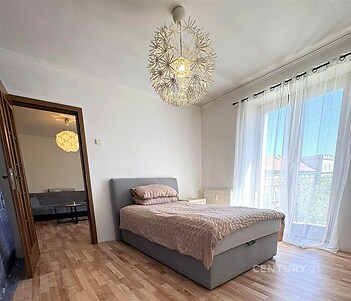 Prostorná ložnice, parketová podlaha, velká okna, moderní osvětlení, slunná atmosféra, přístup na balkon, světlé stěny, kvalitní materiály