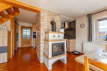 Kuchyň s dlažbou, krbová kamna a dřevěné prvky, moderní styl, světlý interiér, vynikající pro rodinné bydlení