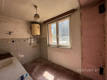 Kuchyň s původním obkladem, velkými okny a bojlerem vyžaduje rekonstrukci, což nabízí skvělou příležitost k modernizaci.