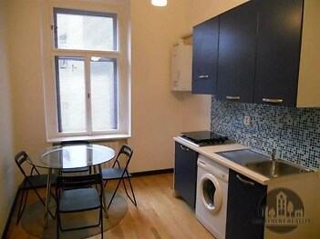 kuchyně s pračka / sušička, přirozené světlo, backsplash, ohřívač vody, a dřevěná podlaha