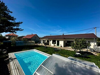 Zahrada s bazénem a moderní rodinný dům, upravený trávník, krytý bazén, klidná lokalita.