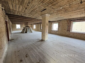 Prostorný podkrovní prostor, surová dřevěná podlaha, kamenné stěny, velká okna nabízejí dostatek přirozeného světla, ideální pro rekonstrukci.