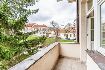 Balkon s dlažbou nabízí výhled na zeleň, přístup z prosklených dveří, ideální pro relaxaci. Vhodný pro rekonstrukci na moderní prostor.