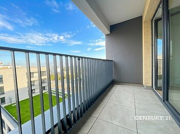 Balkón s moderní dlažbou a kovovým zábradlím nabízí panoramatický výhled na město. Ideální prostor pro relaxaci v nově zrekonstruované budově.