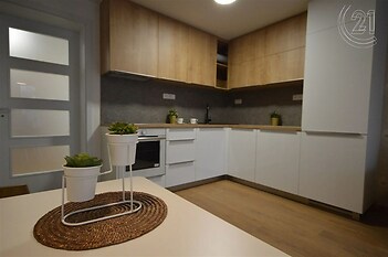 kuchyně s otevřené police, dřevěná podlaha, backsplash, trouba, a ploché panelové skříňky