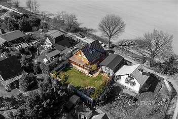 Rodinný dům s moderní střechou a velkou terasou, obklopený udržovanou zahradou. Klidná lokalita, prostorný pozemek, ideální pro rodinné bydlení