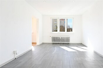 Světlý obývací pokoj s velkými okny, moderní parketová podlaha, bílý strop s vestavěným osvětlením, nově rekonstruovaný stav.