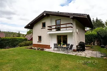 Moderní rodinný dům s terasou, velkými okny a zahradou, situovaný v klidném prostředí. Vhodný pro rekreaci nebo trvalé bydlení.