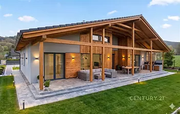 Prostorná terasa s dlažbou, dřevěné obložení, moderní design, velká okna propojující interiér s exteriérem, ideální pro relaxaci venku.