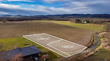 Stavební pozemek s rozlohou 1044 m², obklopený krásným výhledem na krajinu, v klidné lokalitě poblíž vesnice, ideální pro rodinný dům.