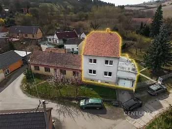 Rodinný dům se zahradou, renovovaný exteriér, červená střecha, klidná venkovská lokalita, asfaltová přístupová cesta, prostorný pozemek.