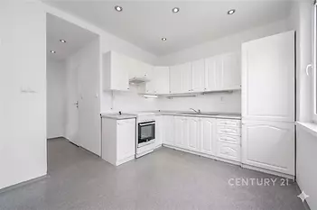 Světla kuchyň s moderním designem, bílými skříňkami a vestavěnými spotřebiči, praktická dlažba na podlaze, ideální pro rodinné vaření