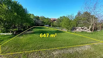 Prázdný stavební pozemek o rozloze 647 m², obklopený zelení a stromovím, ideální pro výstavbu rodinného domu, klidná lokalita v přírodě.