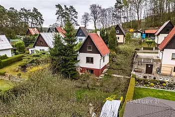 Rodinný dům se zahradou, v klidné oblasti s okolní zelení. Střecha z plechu, styl venkovský.