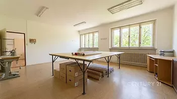 Prostorná pracovna s velkými okny, parketovou podlahou a světlým interiérem, ideální pro kreativní projekty nebo kancelářské využití.