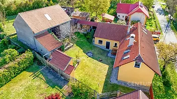 Dům se zahradou obklopenou zelení, žlutá fasáda, červená střecha, venkovský styl, klidná lokalita, prostorný venkovní prostor, dvě budovy.