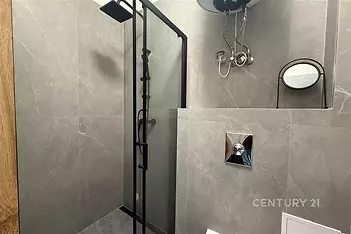 Moderní koupelna s keramickými obklady, sprchovým koutem a elegantními kovovými detaily.
