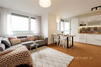 Světlý obývací pokoj s moderní kuchyní, parketová podlaha, velká okna, zařízený v skandinávském stylu, příjemná atmosféra pro bydlení. Hana Yates realitní makléřka pro Prahu.