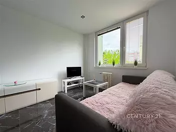 Světlý obývací pokoj s mramorovou dlažbou, velkými okny a moderním nábytkem.