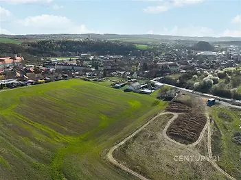 Zemědělský pozemek s výhledem na obec, rovinatá lokalita, strategická poloha poblíž zástavby. Potenciál pro různé využití.