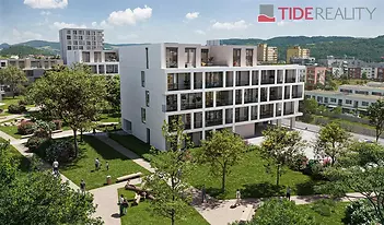 Moderní bytový komplex s velkými okny, obklopený upraveným parkem. Budova má světlou fasádu a nachází se v klidné rezidenční čtvrti.