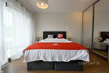 Prostorná ložnice s parketovou podlahou, velká okna pro přirozené světlo, vestavěné skříně zajišťují dostatek úložného prostoru.