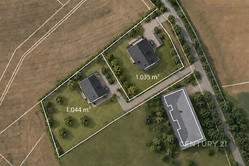 Letecký pohled na dvě pozemky s rodinnými domy, každý o rozloze přes 1000 m², obklopený zelení a přístupovou cestou v přírodním prostředí.