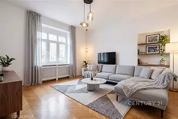 Světlý obývací pokoj s parketovou podlahou, velká okna, moderní nábytek a minimalistický dekor, ideální pro komfortní bydlení.