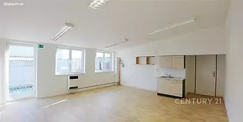 Světlý obývací pokoj s parketovou podlahou a velkými okny, moderní otevřený kuchyňský kout s dřevěným nábytkem, skvělý stav.