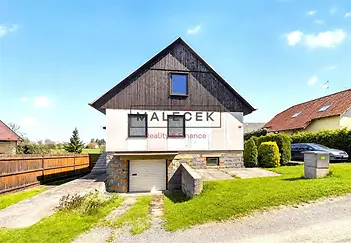 Rodinný dům s moderní dřevěnou fasádou, kamenné detaily, velká zahrada, klidná lokalita.