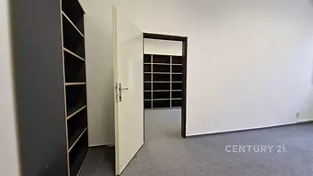 Prázdná kancelář s kobercovou podlahou, bílými stěnami a vestavěnými policemi, moderní design vhodný pro podnikání