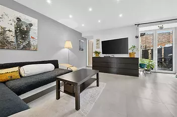 Moderní obývací pokoj, dlažba, velká okna, světlý interiér s moderním nábytkem.