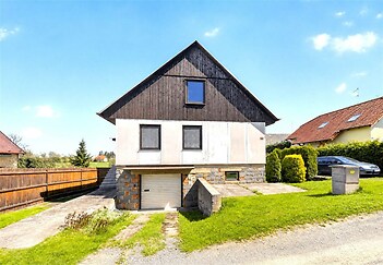 Rodinný dům s moderní dřevěnou fasádou, kamenné detaily, velká zahrada, klidná lokalita.