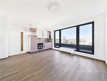 Světlý obývací pokoj s moderní kuchyní, parketová podlaha, velká okna, rekonstruovaný interiér.