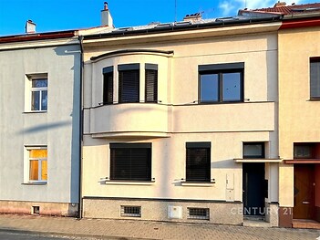 Fasáda řadového domu s moderním designem, plastová okna, zrekonstruovaná omítka, čisté linie a elegantní barvy.