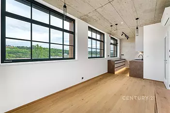 Světlý obývací pokoj s parketovou podlahou a velkými okny, moderní betonový strop, minimalistický design, přírodní výhled